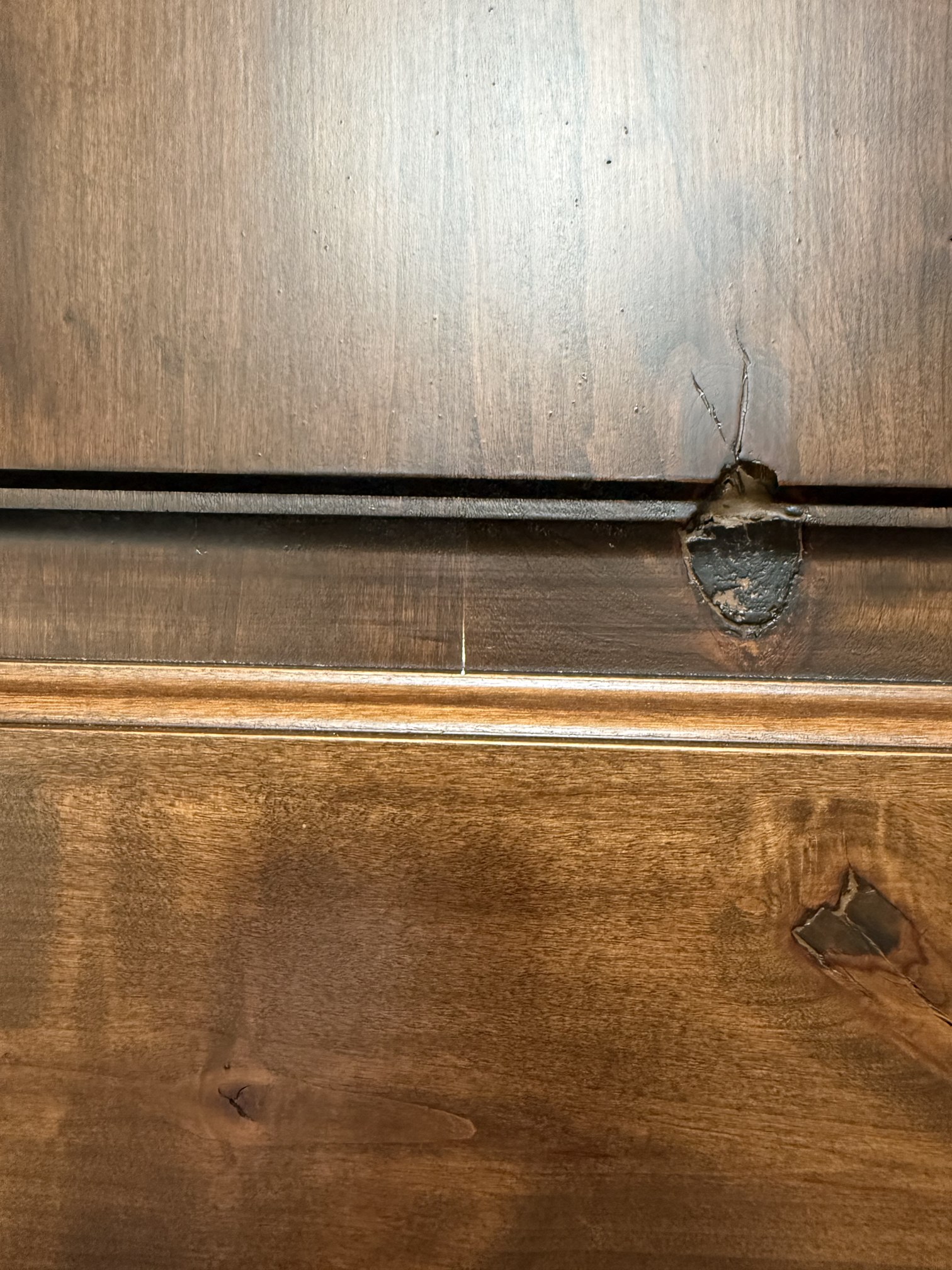 Close-up of a separated joint and filled gap on the wood entry door before refinishing