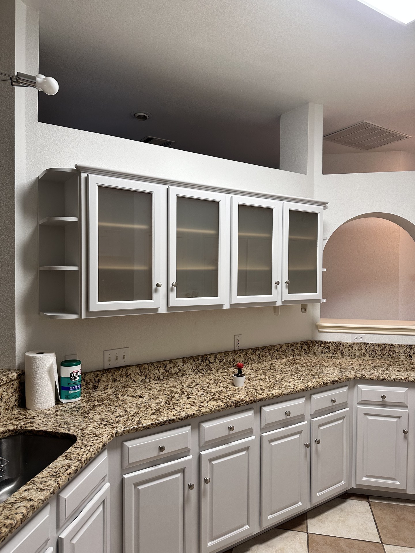 Kitchen cabinets painted a crisp bright white with granite countertops kept in place in Austin