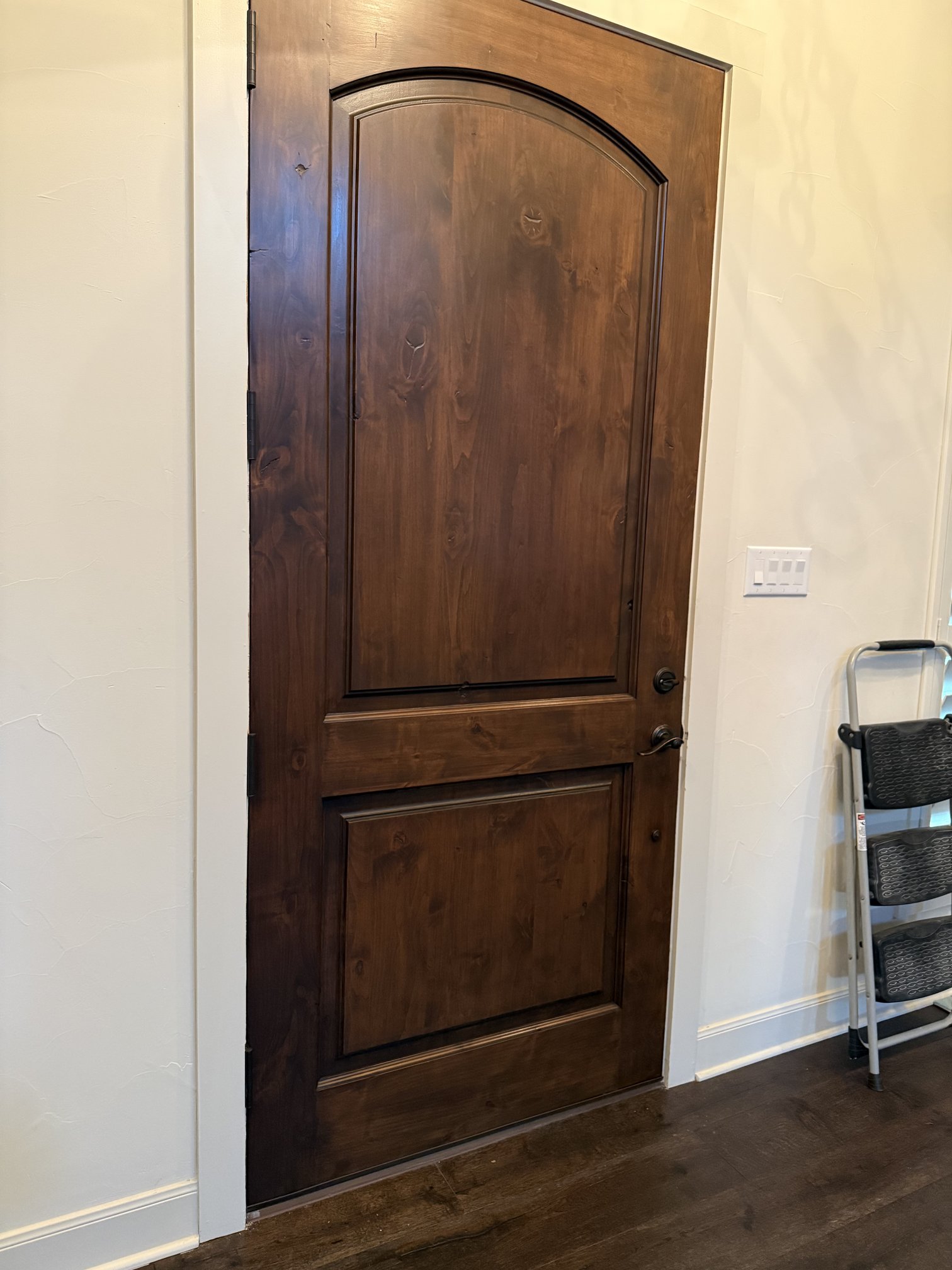 Interior side of the refinished entry door with a rich, even dark-brown finish in New Braunfels